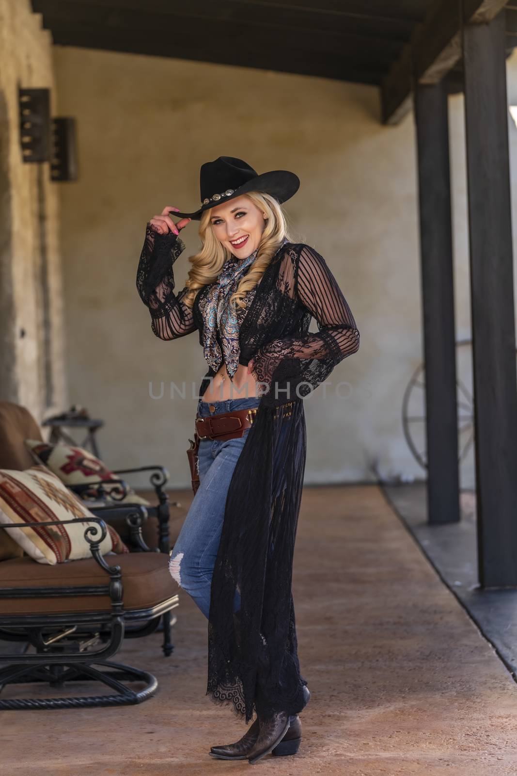 A gorgeous blonde model dressed as a cowgirl enjoying the outdoor weather