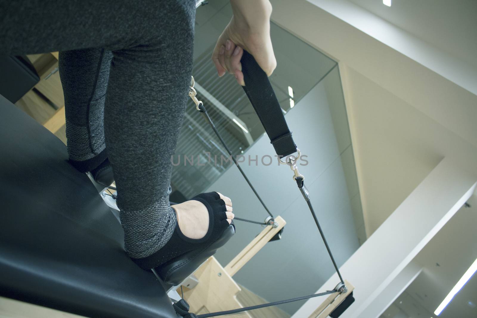 Woman doing pilates machine. Exercises to stretch the muscles by GemaIbarra