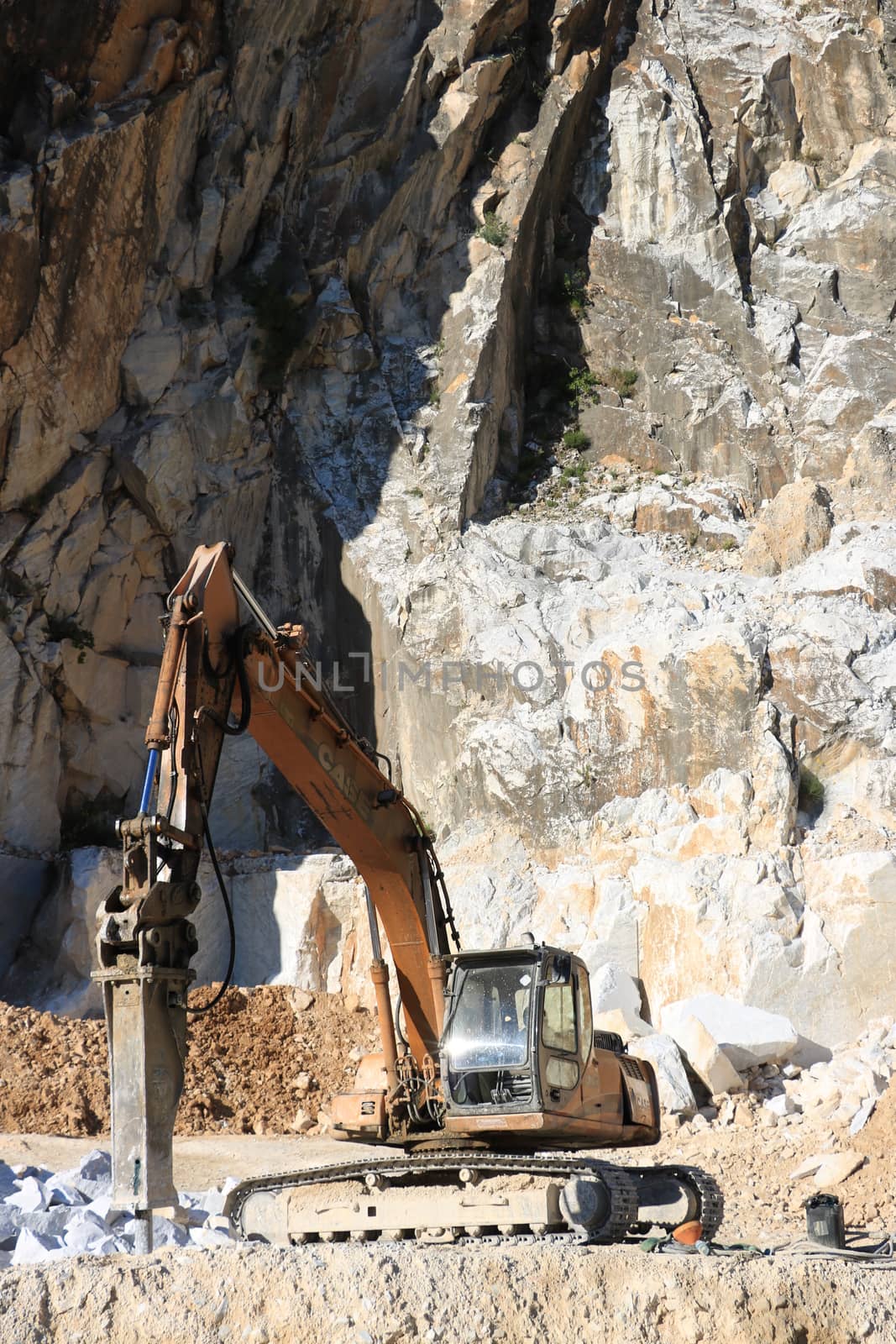 Excavator with demolition hammer in a Carrara marble quarry. A l by Paolo_Grassi