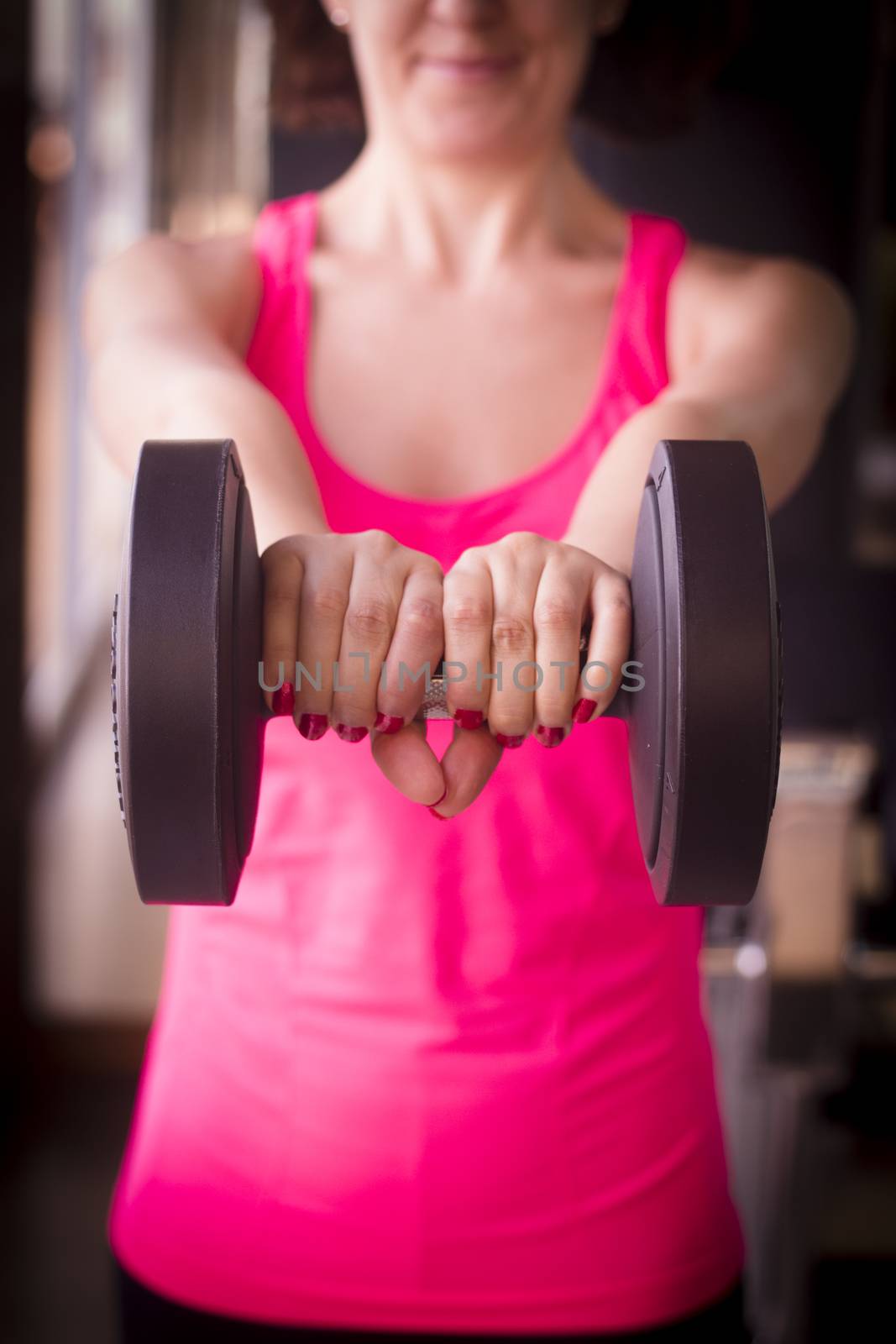 Girl doing exercise with 4 kg weights in the gym