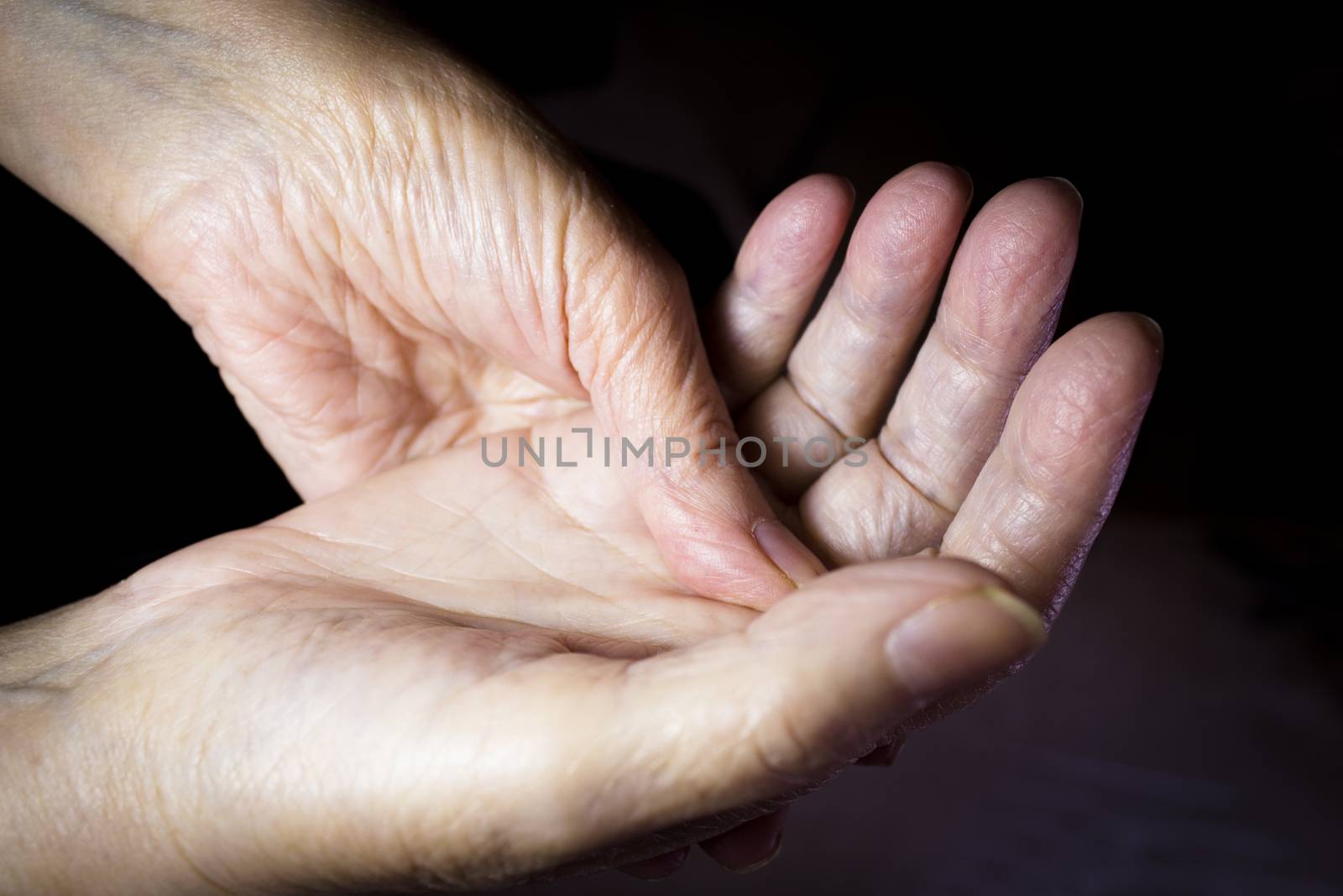 Hands of elderly woman doing a selfmassage. Manual physiotherapy 