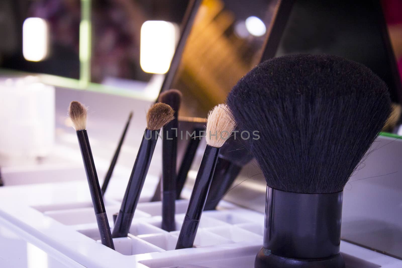 Plastic holder with various used makeup brushes. No people
