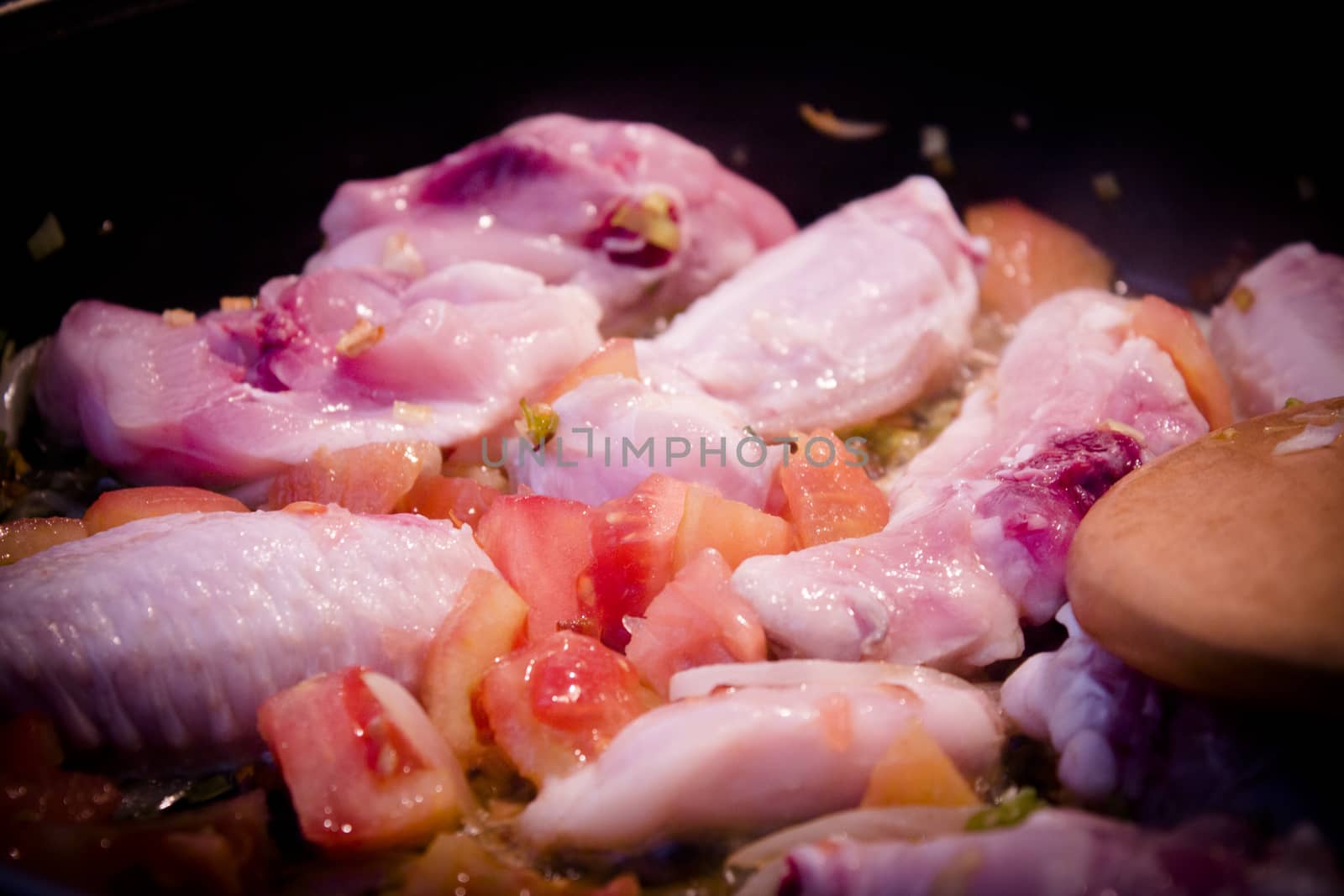 Vegetable stir fry with chicken wings to make paella. No people
