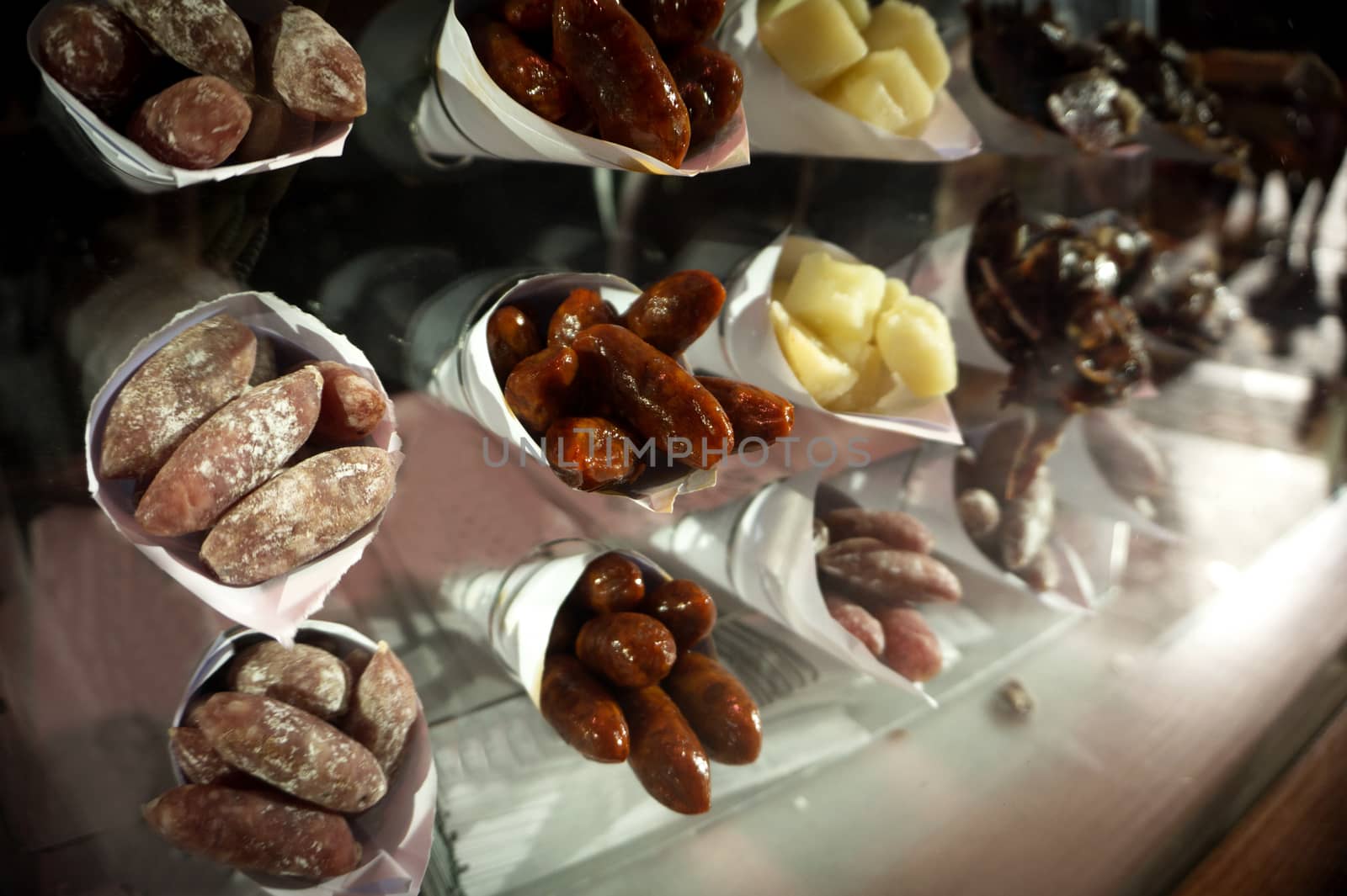 Paper cones filled with different sausage and cheeses. No people