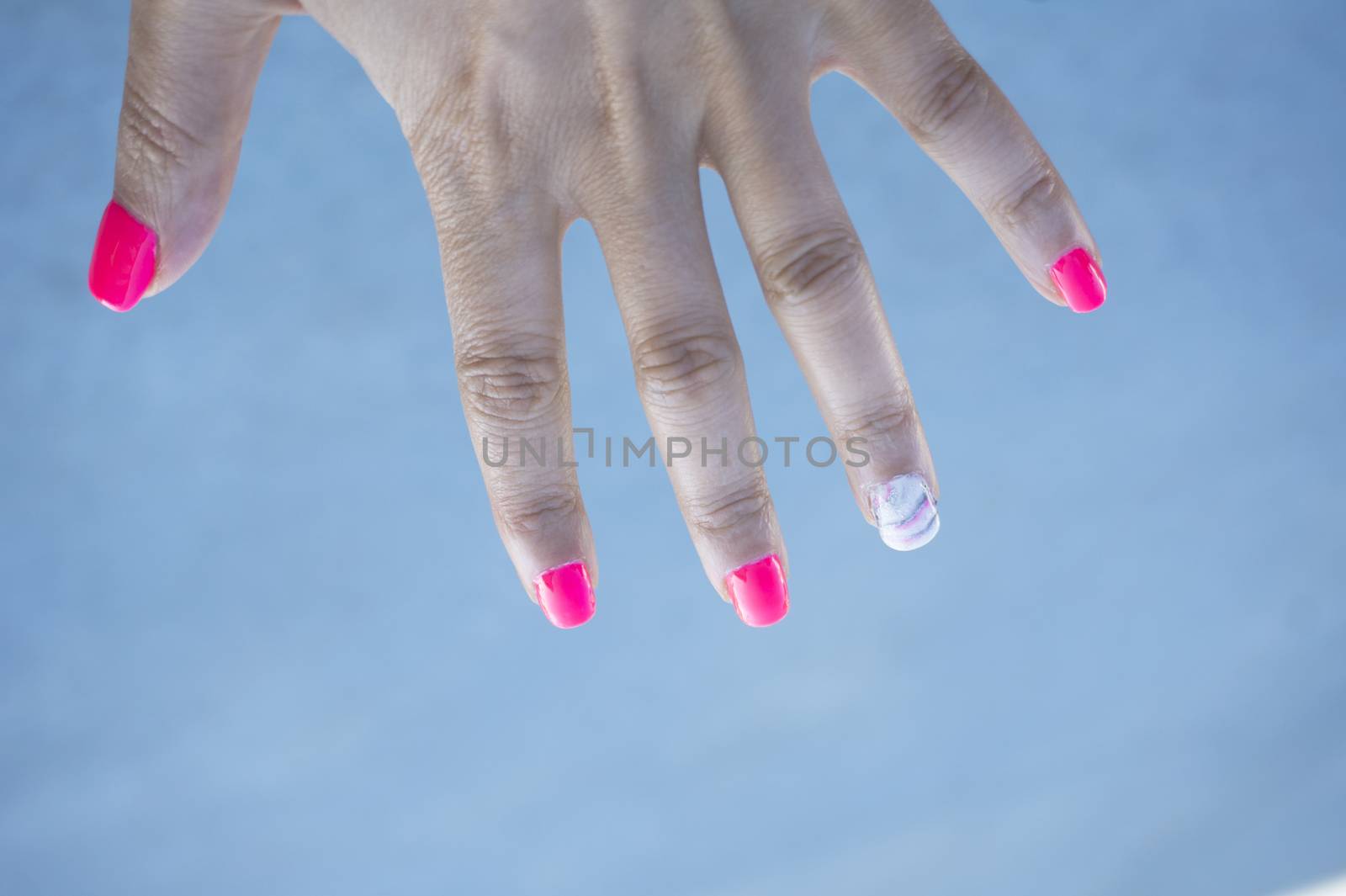 Womans hand showing her semipermanent manicure. Pink colour