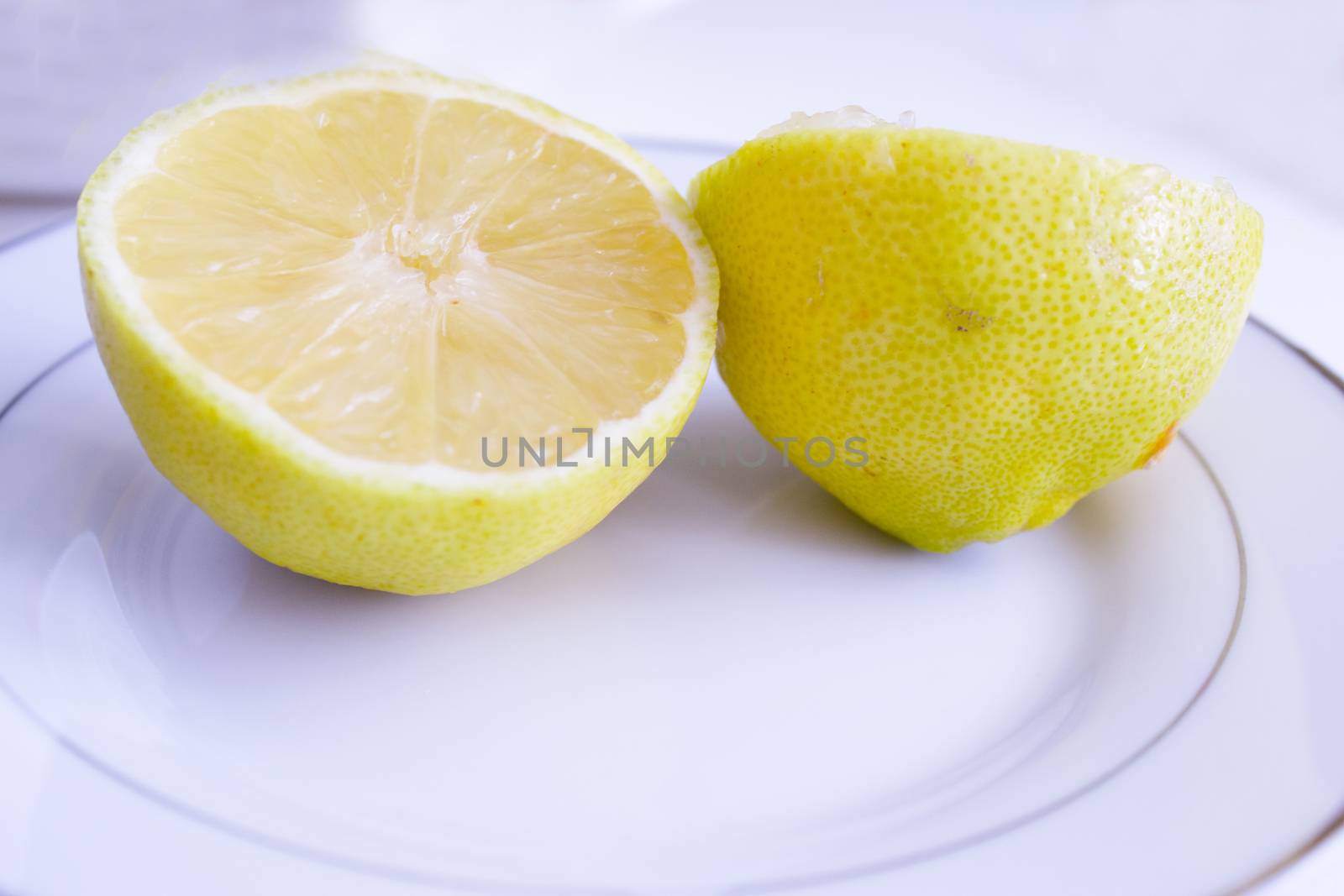 Half lemon cut on wooden cutting board. No people