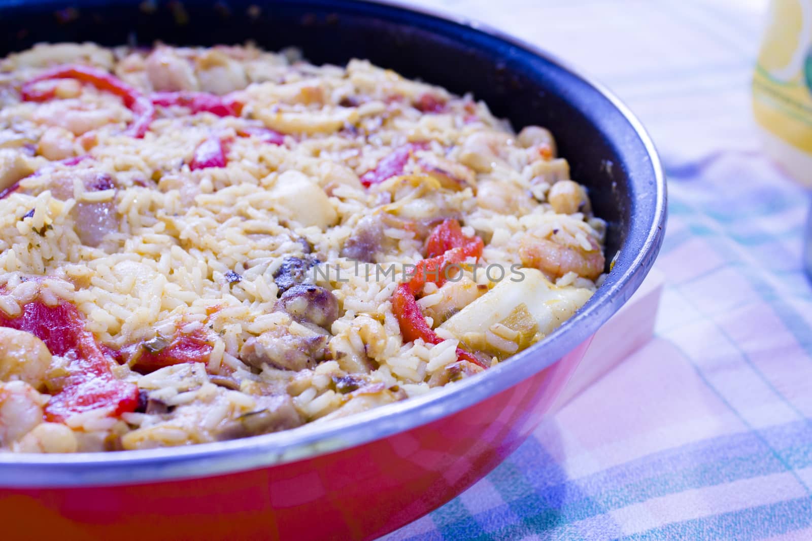 Rice paella cooked with chicken, seafood and vegetables. No people