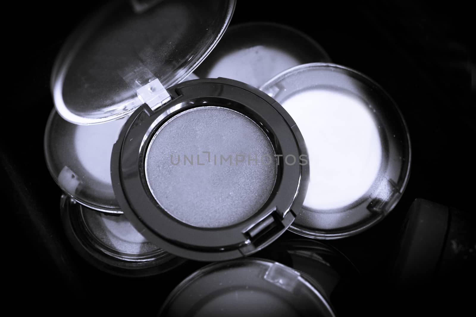 Various makeup shadows on dark background. No people