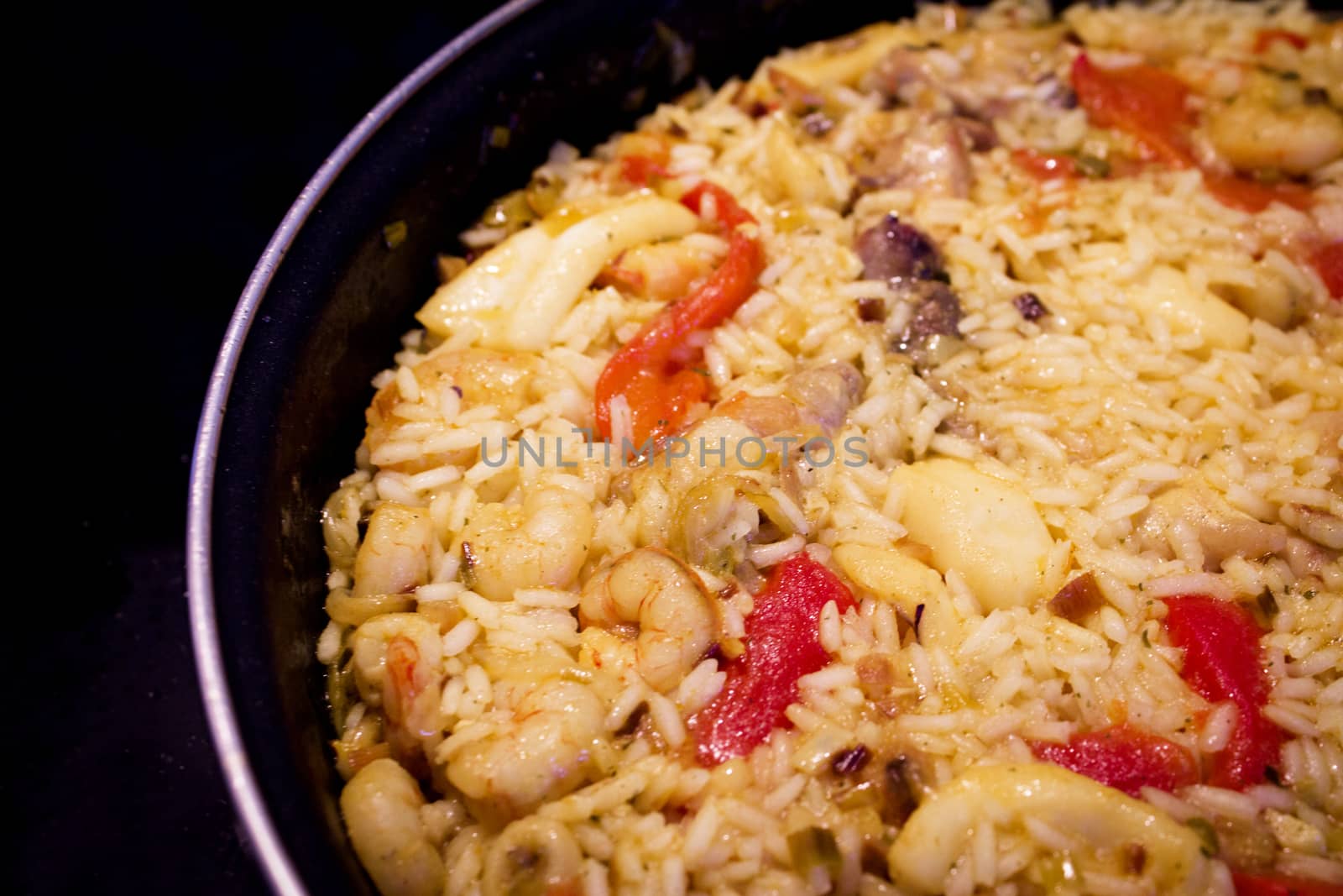 Rice paella cooked with chicken, seafood and vegetables. No people