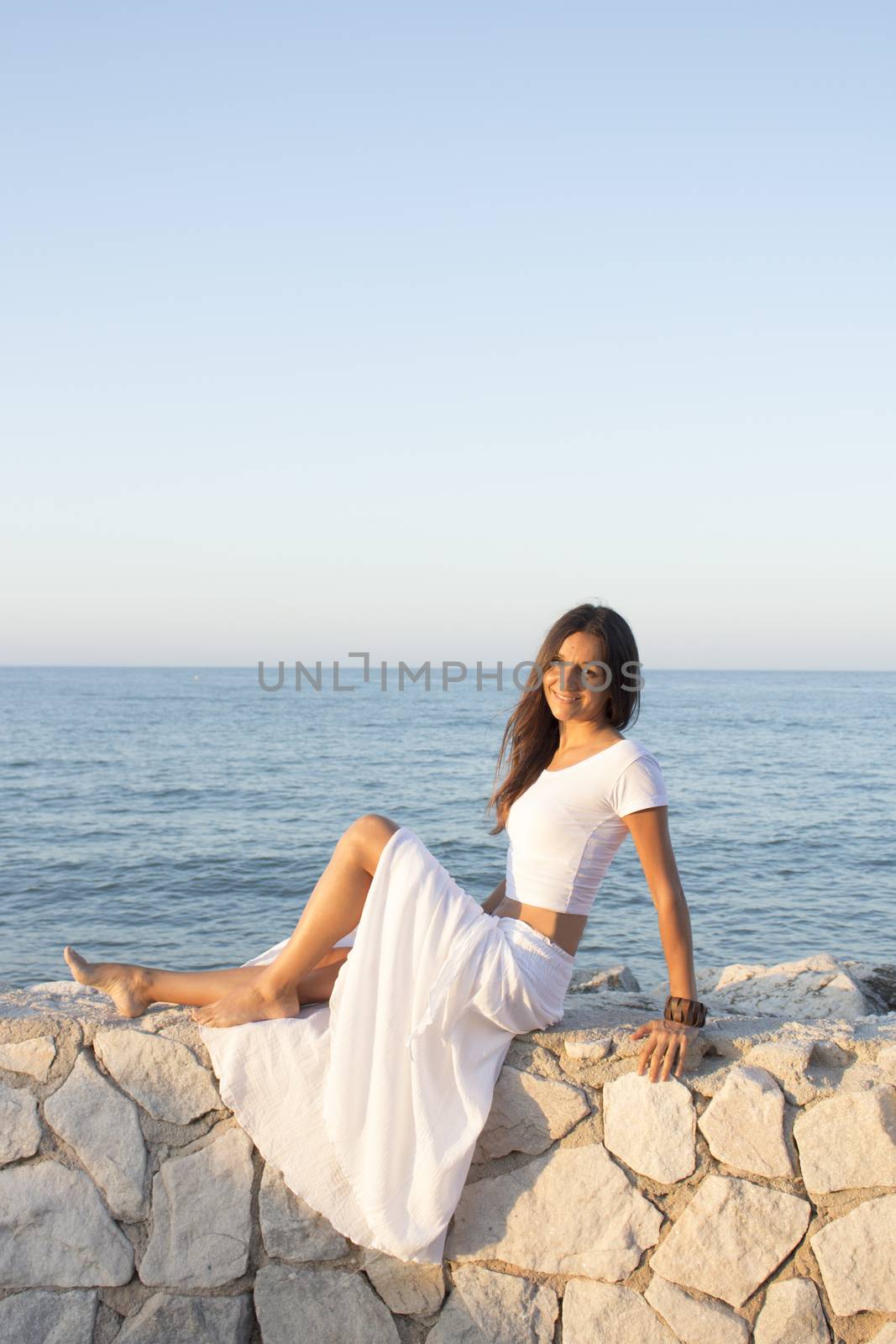 Woman in white dress on the beach with happy expression