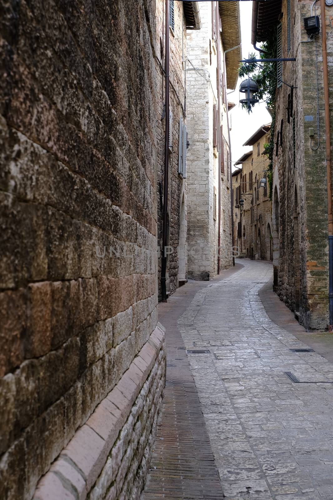 Alley of the city of Assisi with stone facades of historic house by Paolo_Grassi