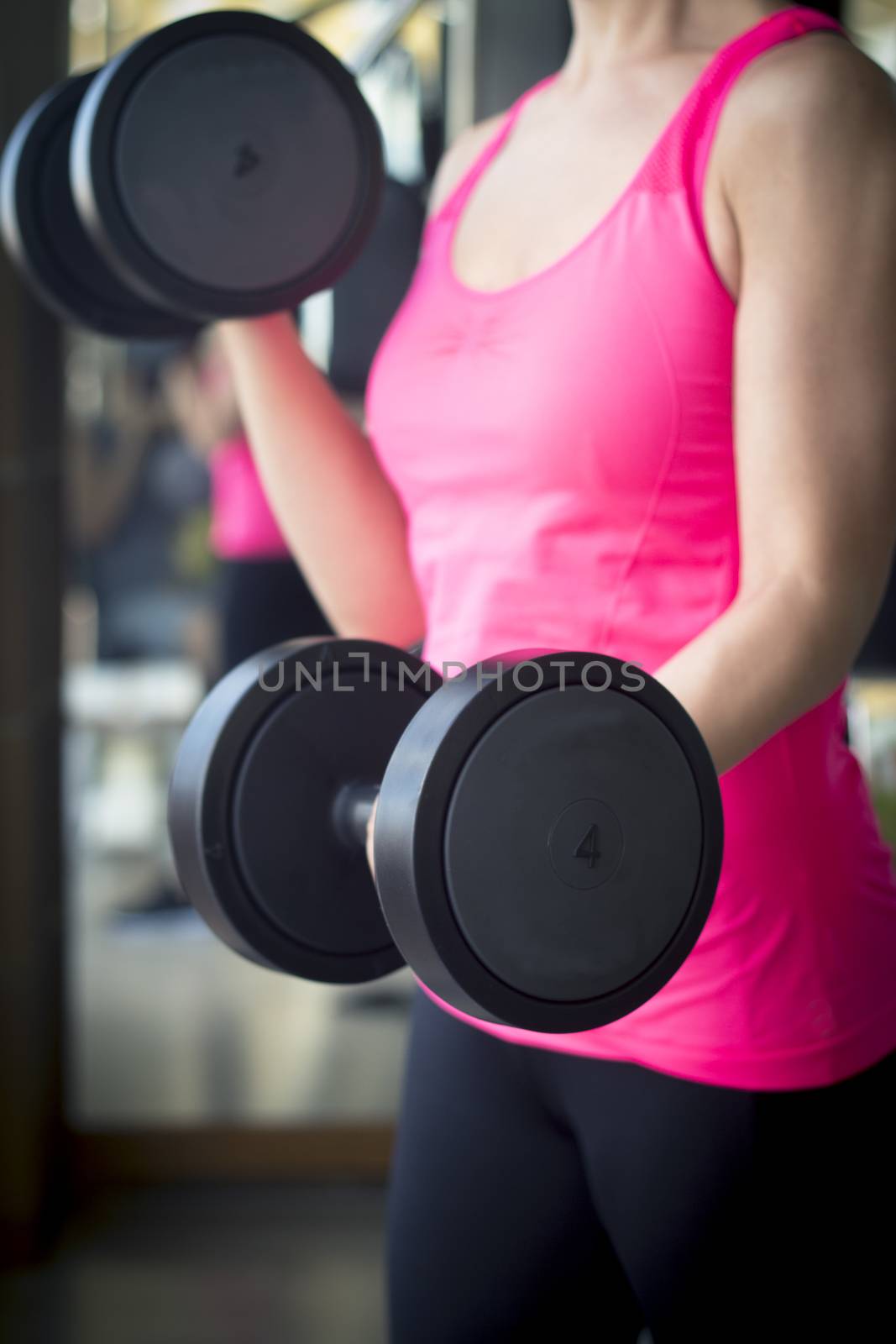 Girl doing exercise with 4 kg weights in the gym