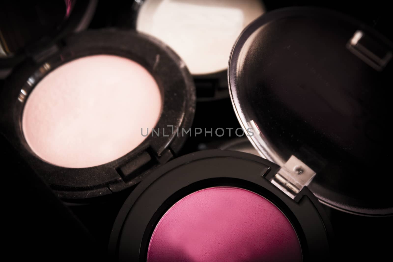 Various makeup shadows on dark background. No people