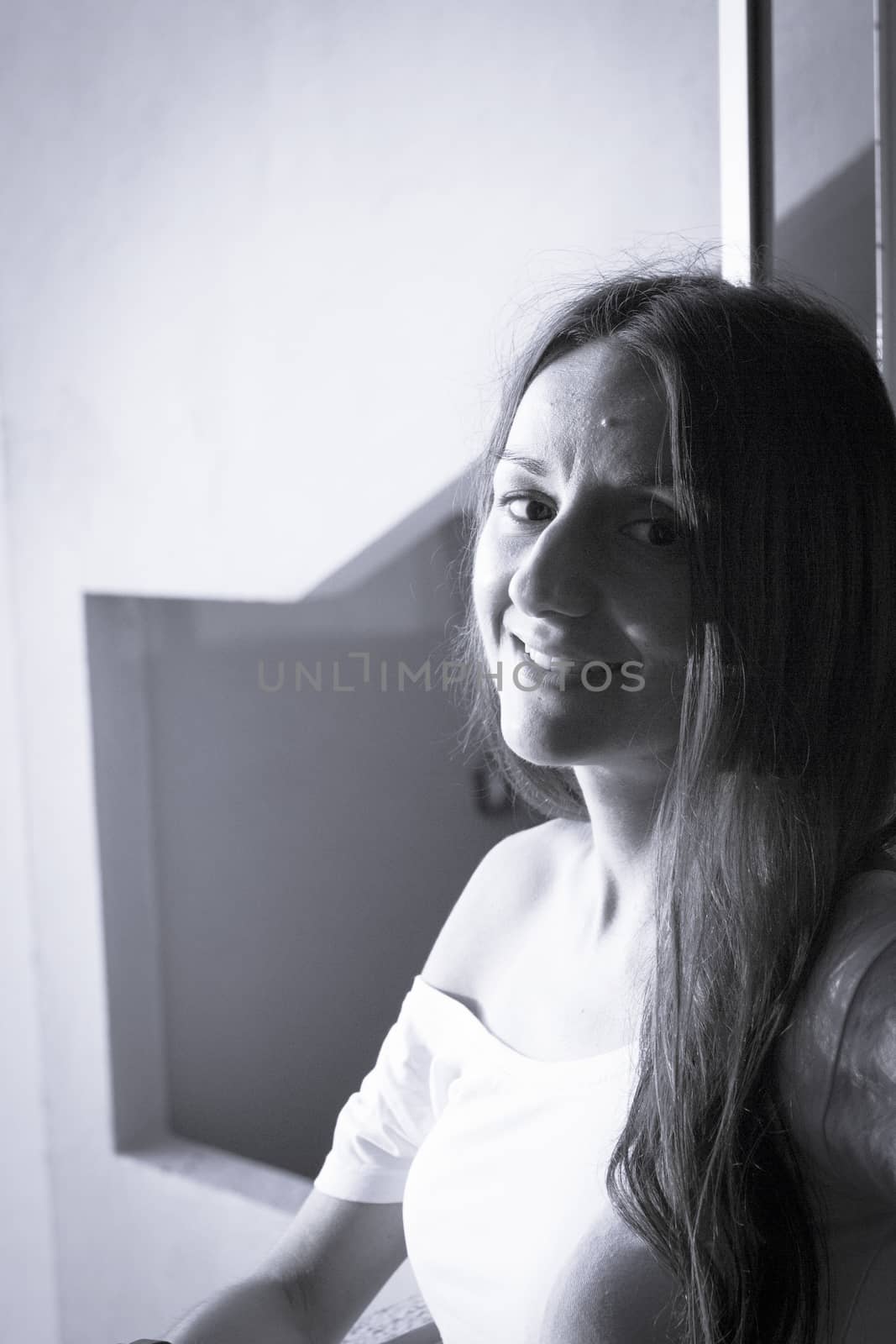 Portrait of young woman with enigmatic expression. Dark background