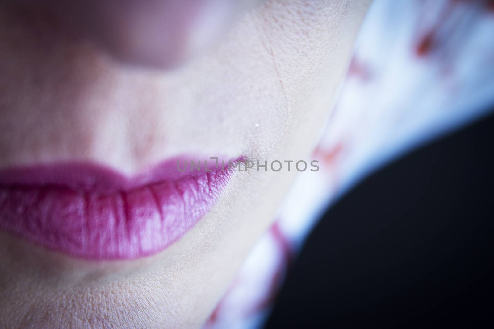 Womans lip painted red pink. No smiling.