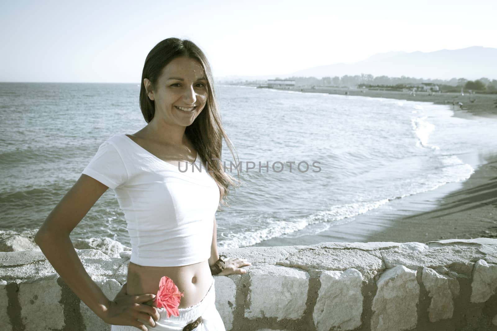 Portrait of young girl dressed in white with the sea in the background