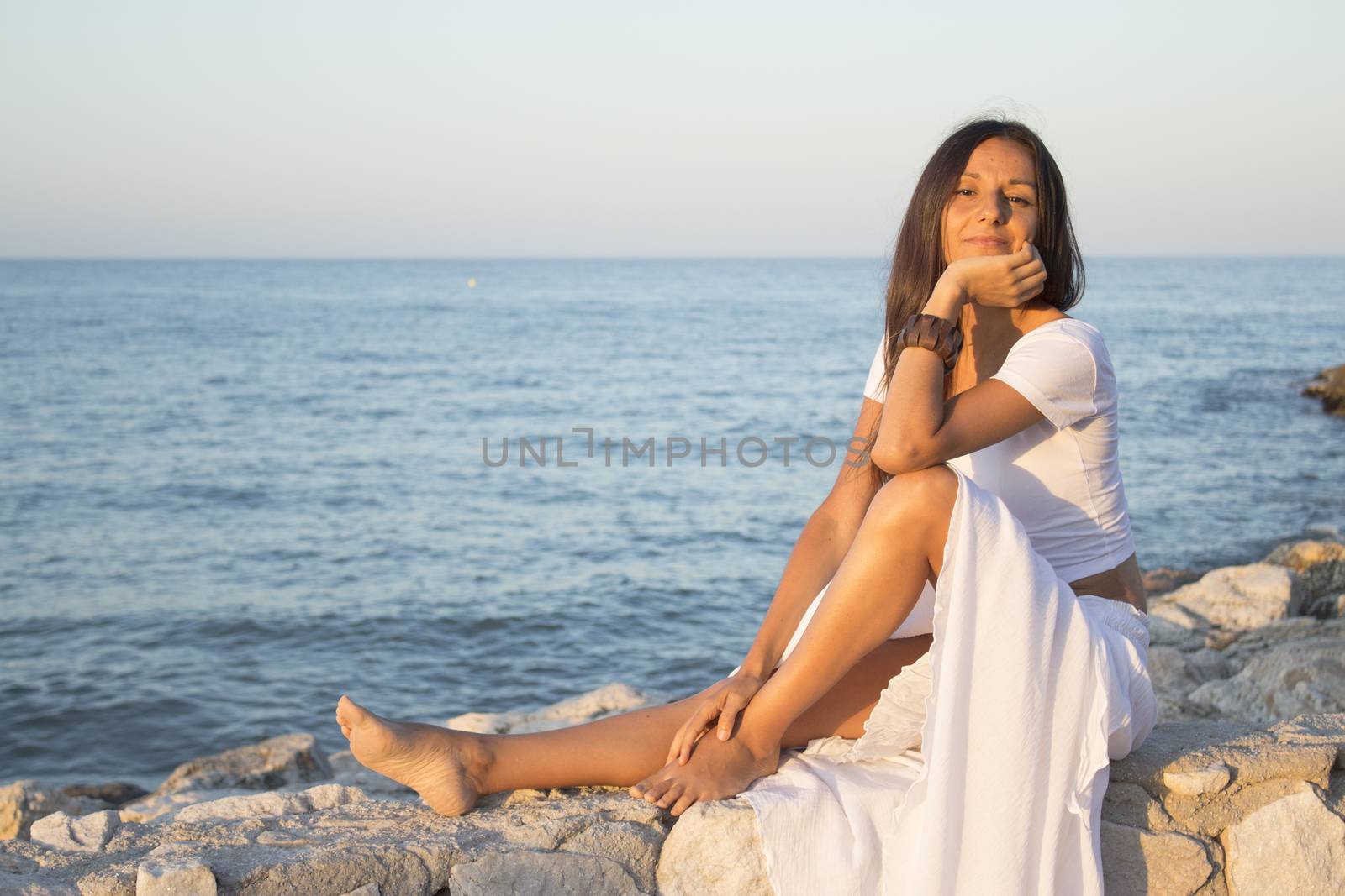 Woman in white dress on the beach with happy expression