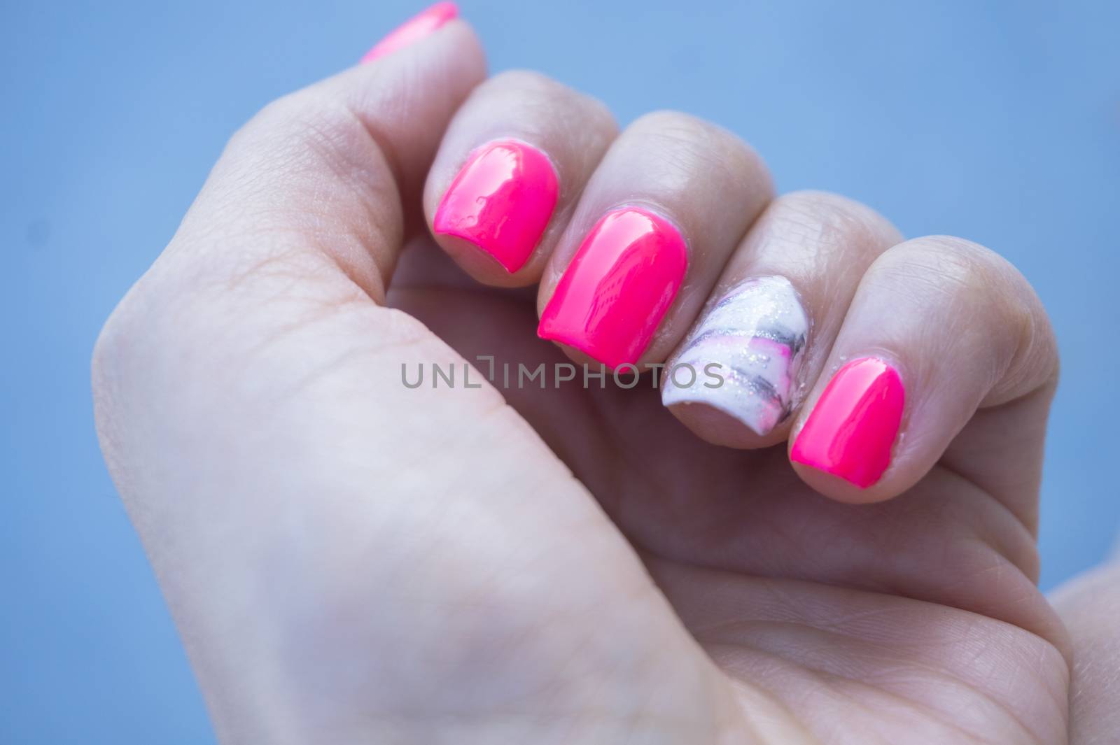 Womans hand showing her semipermanent manicure. Pink colour