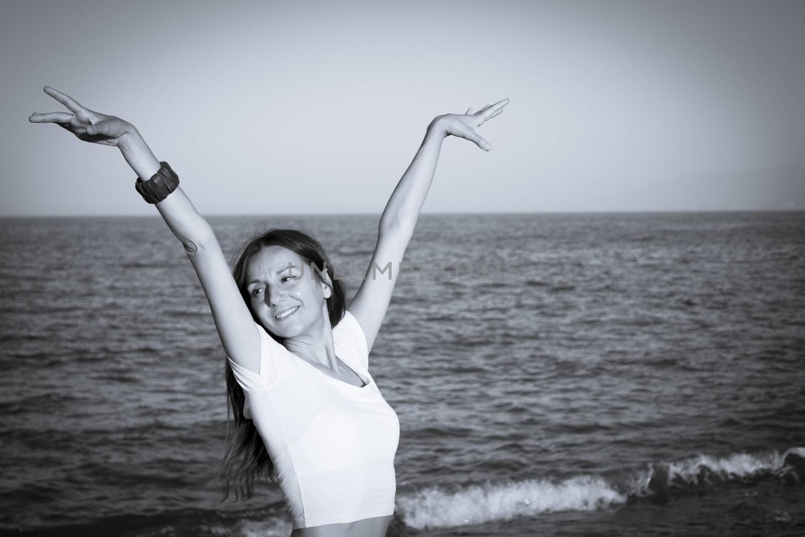 Attractive woman in white dress on the beach. Positive expression