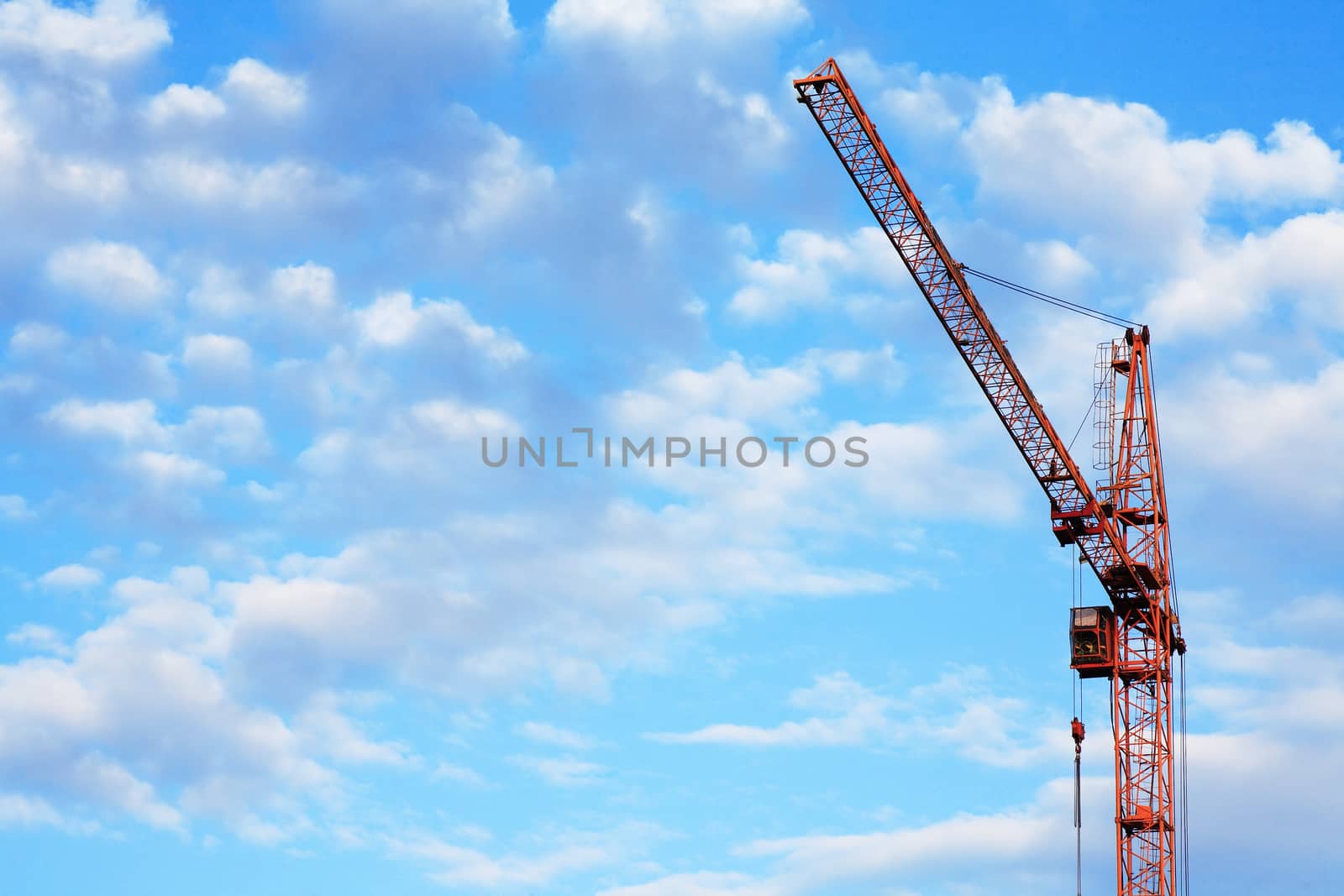 Industrial theme. Yellow construction crane against blue sky