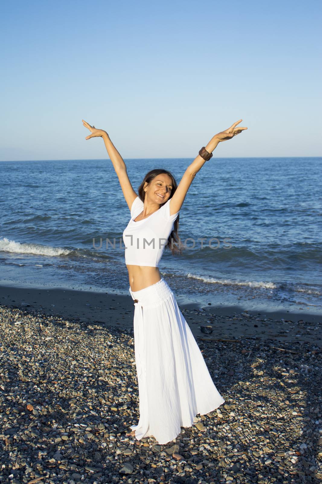 Attractive woman in white dress on the beach. Positive expression