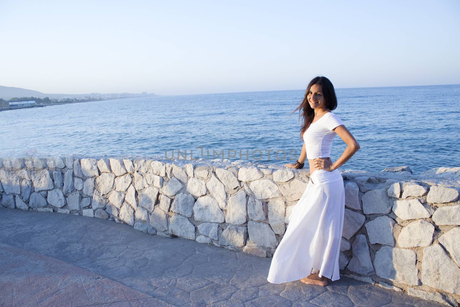 Woman in white dress on the beach with happy expression