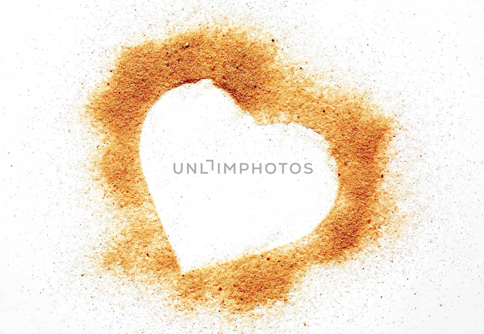 Heart symbol made from sand on white background