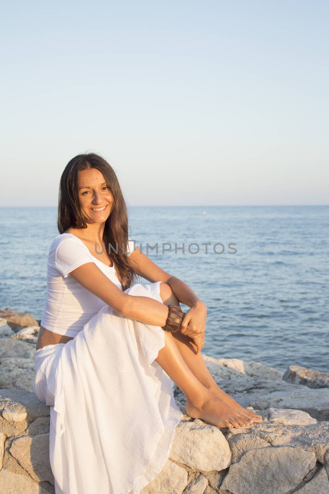 Woman in white dress on the beach with happy expression