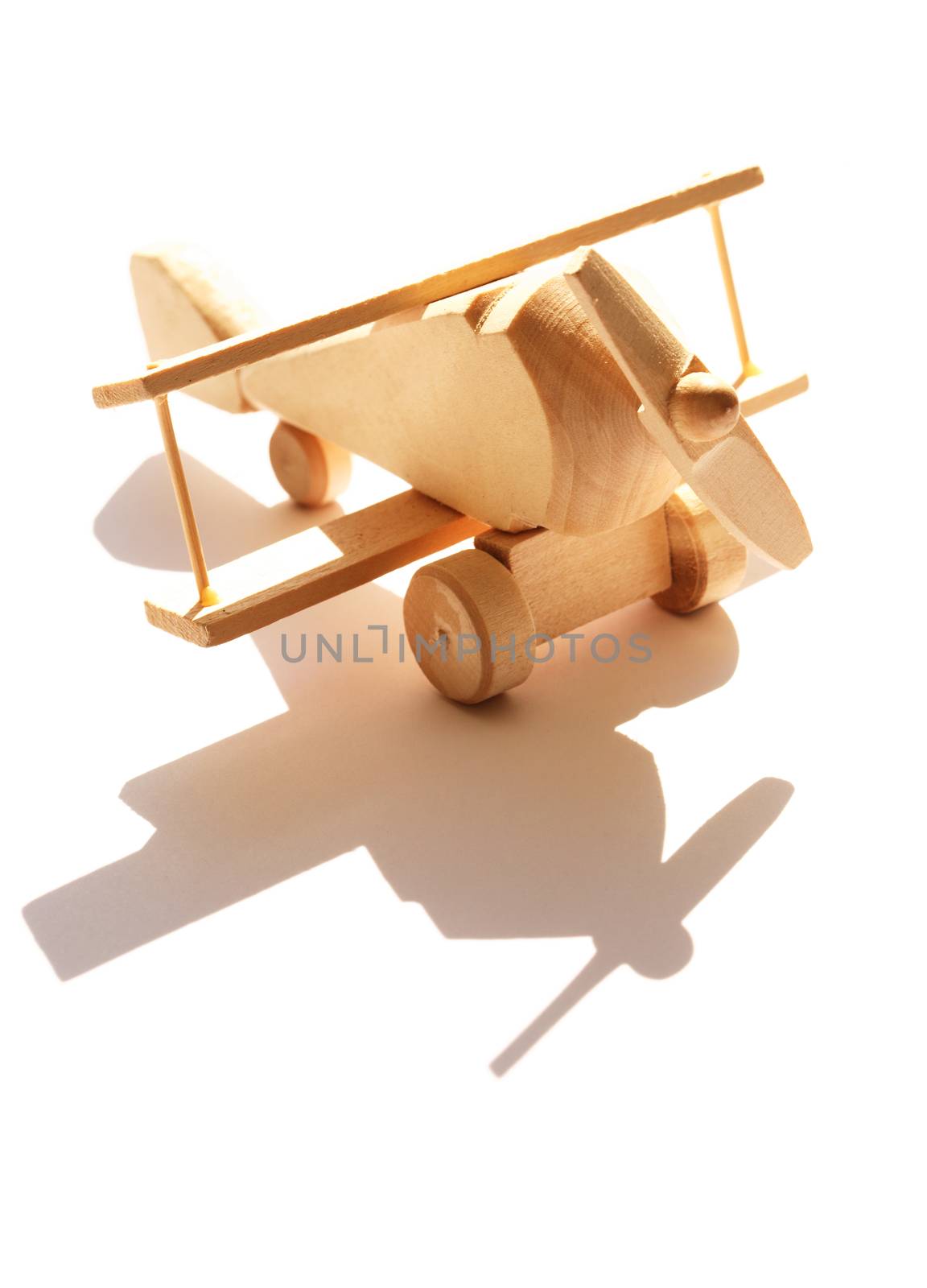 Travel concept. Small wooden airplane against sunlight with shadow