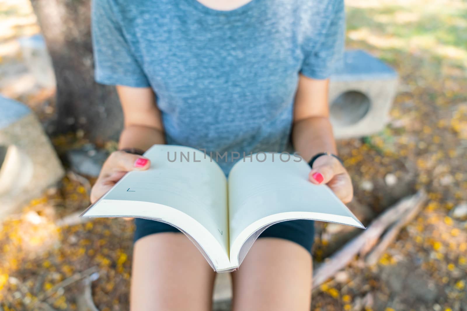 Hand holding a book at garden