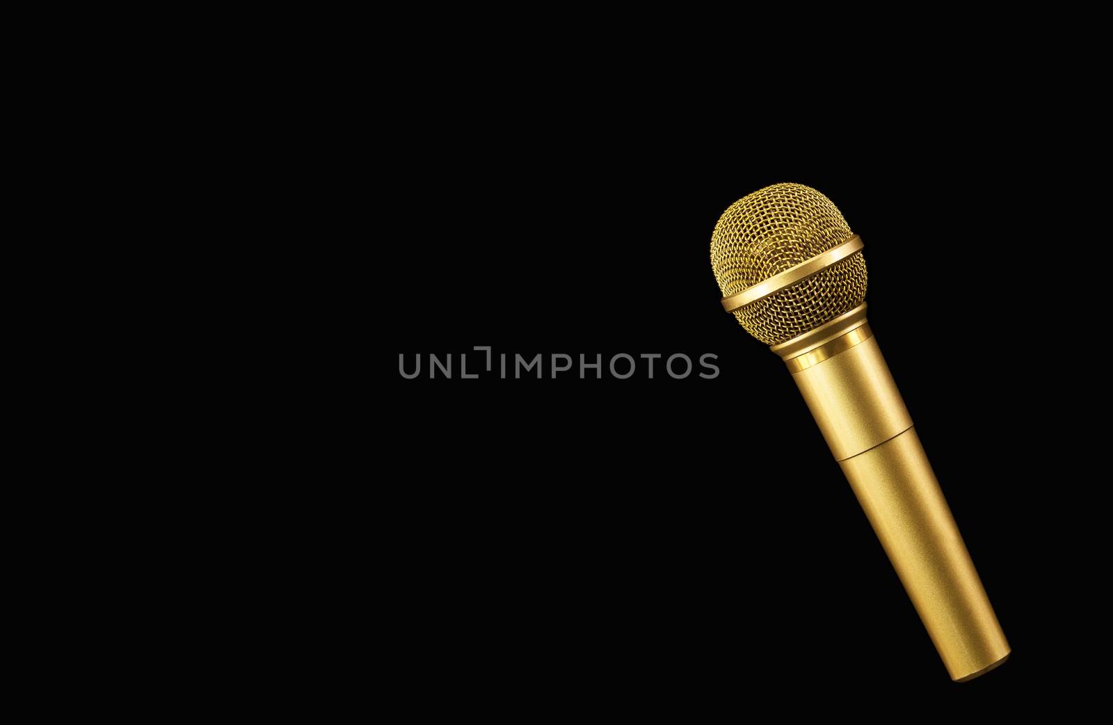 Golden microphone on black background.