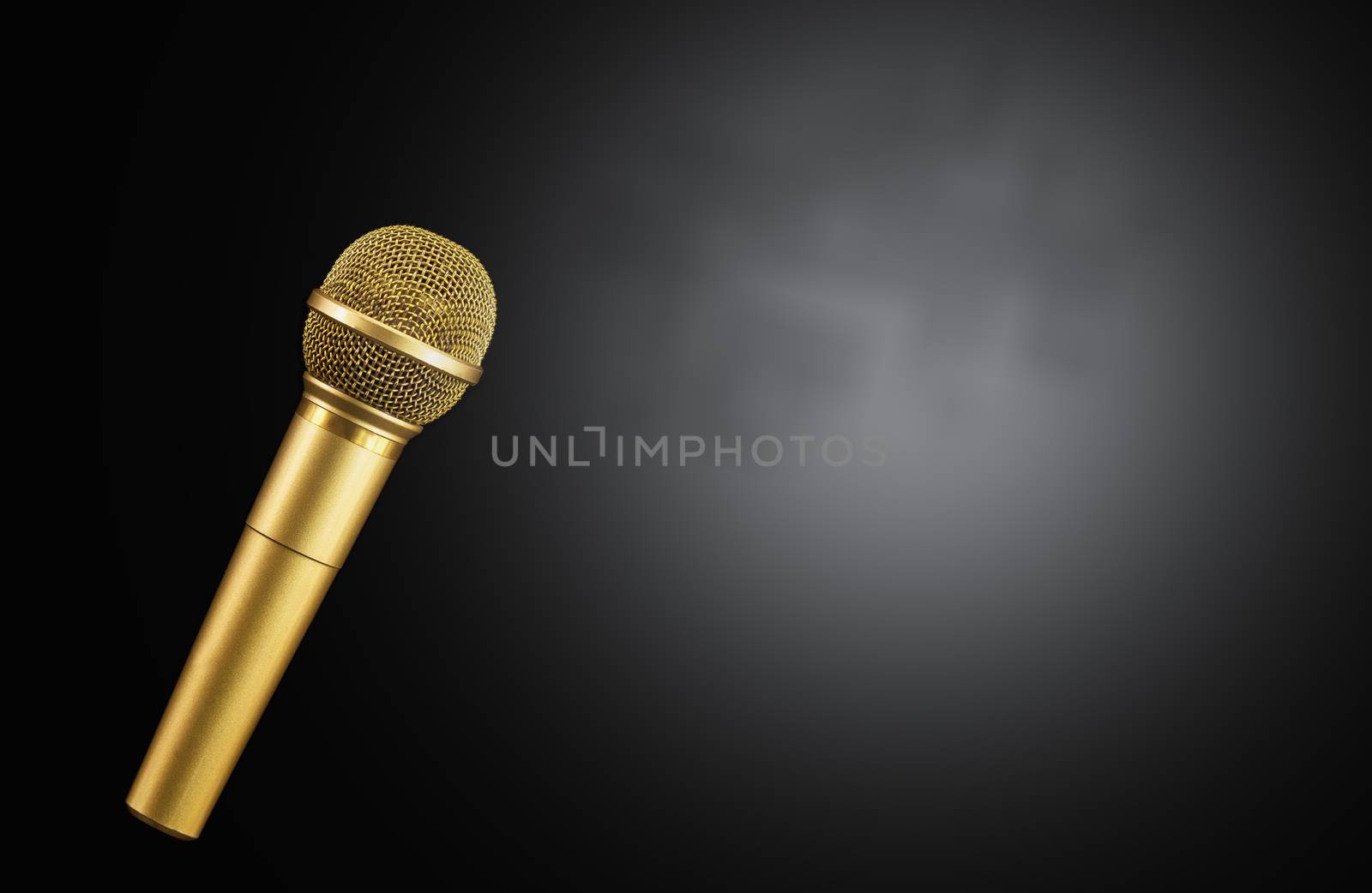 Golden microphone on black background.