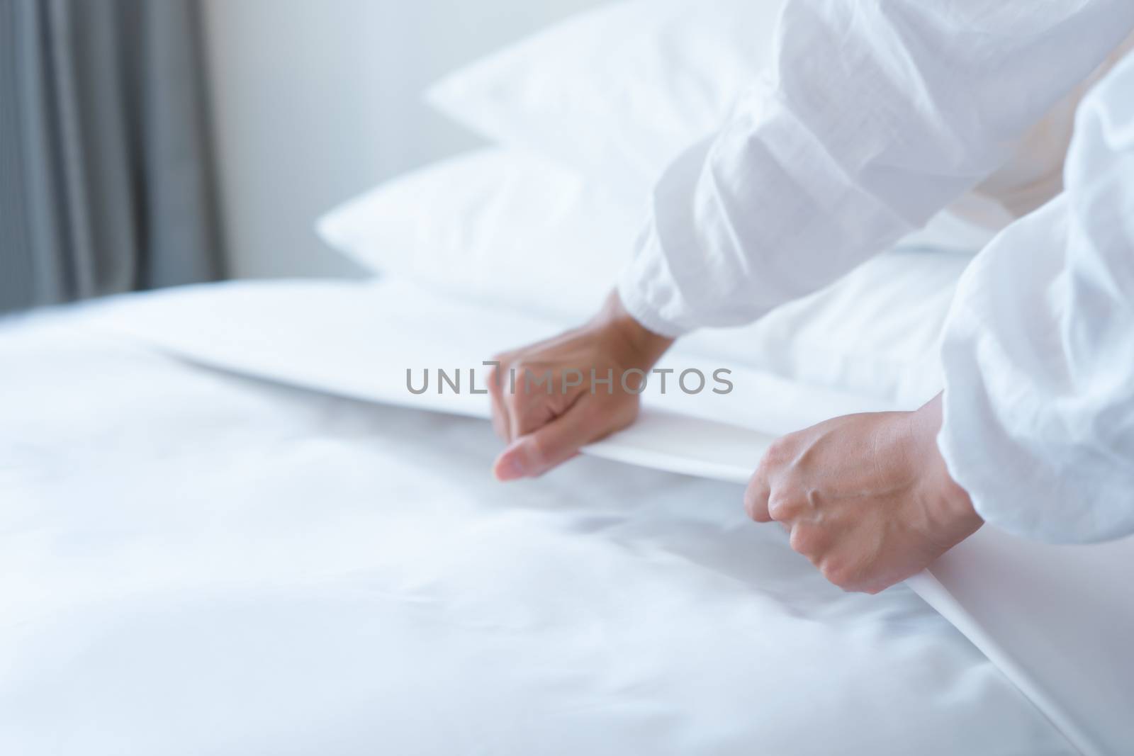 Female Hand set up white bed sheet in bedroom by Buttus_casso