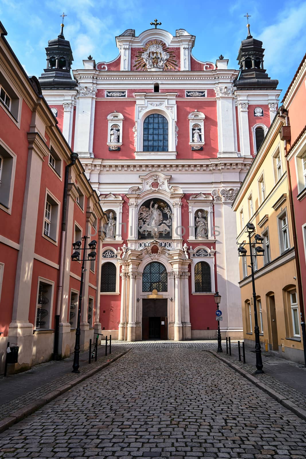 facade of the baroque church decorated with columns and statues in Poznan