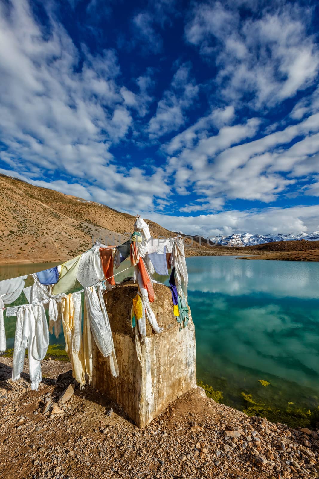 Small gompa with buddhist prayer flags at sacred Dhankar Lake in Himalayas. Spiti Valley, Himachal Pradesh, India