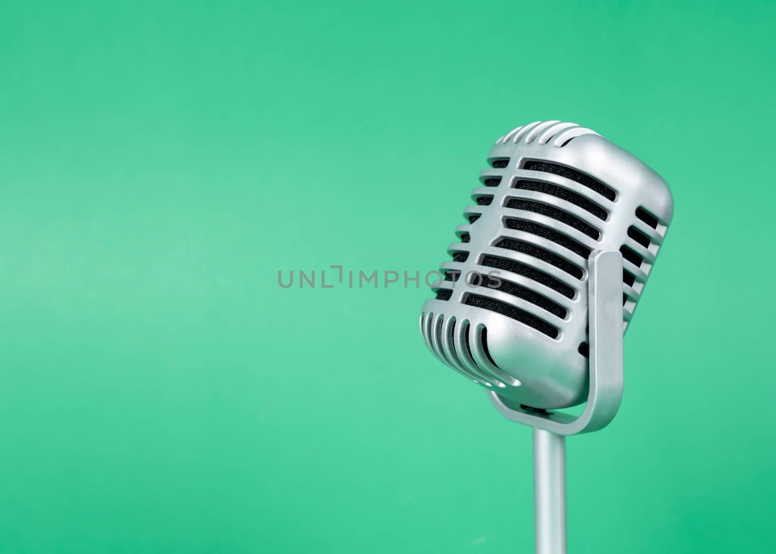 Retro microphone with copy space on green background
