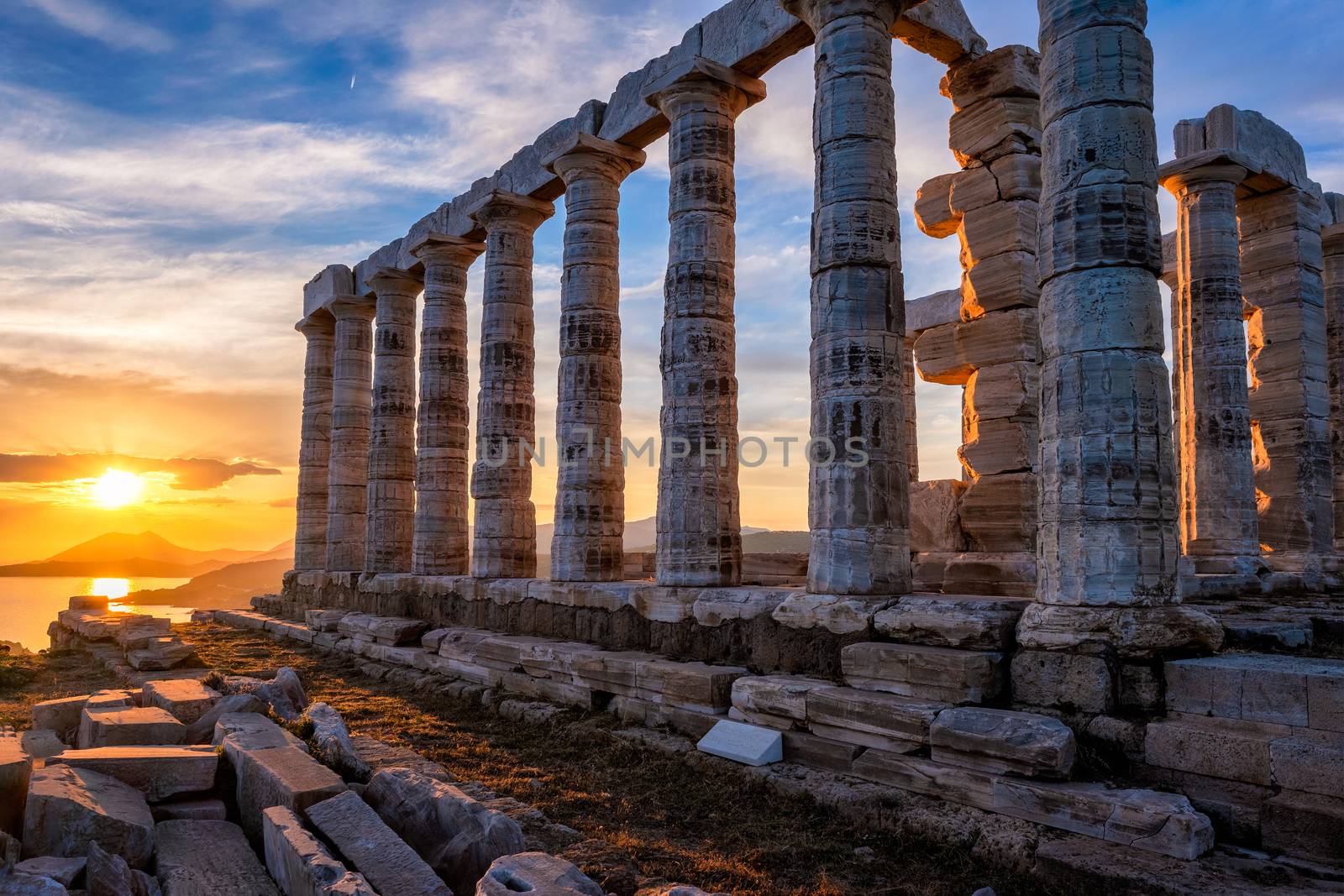 Cape Sounio sunset at Sounion with ruins of the iconic Poseidon temple. One of the Twelve Olympian Gods of ancient Greek religion and mythology. God of the sea, earthquakes. Aegean coast, Greece.