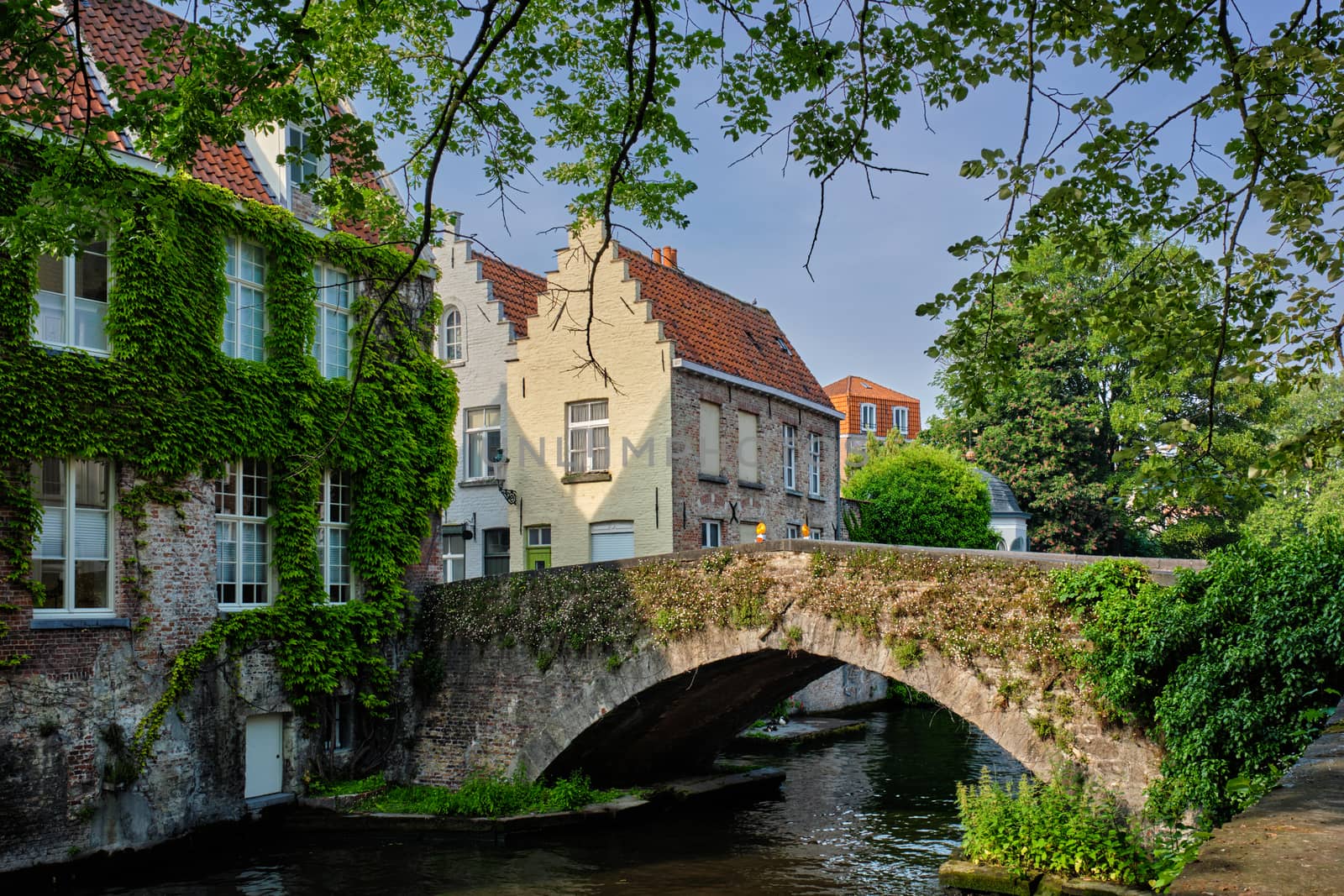 Bruges typical Belgian cityscape Europe tourism concept - canal and old houses and bridge. Brugge, Belgium