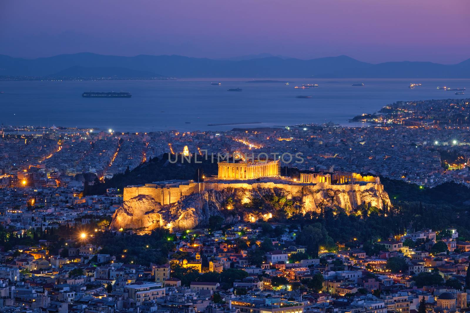 Parthenon Temple on hill is the antique tourist landmark at the Acropolis of Athens and ancient European civilization architecture on Aegean sea coast. Dusk view from Mount Lycabettus, Athens, Greece