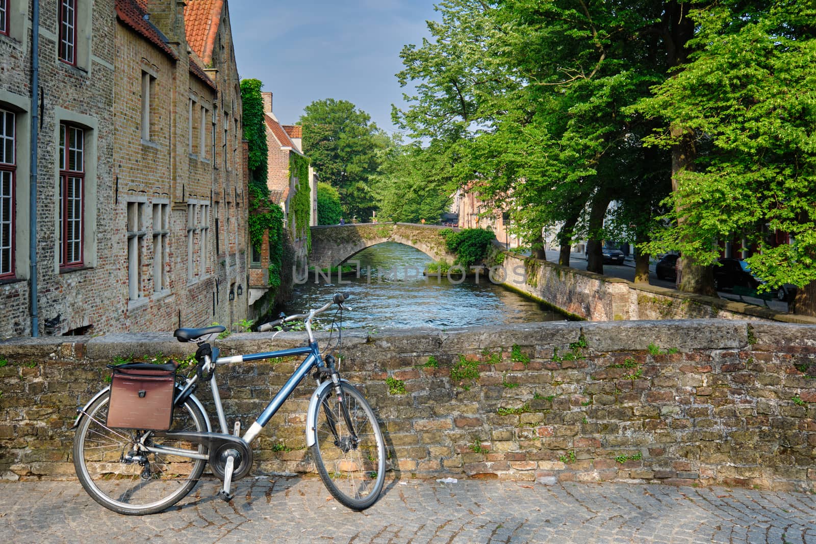 Bicyccle on a bridge near canal and old houses. Bruges Brugge , Belgium by dimol