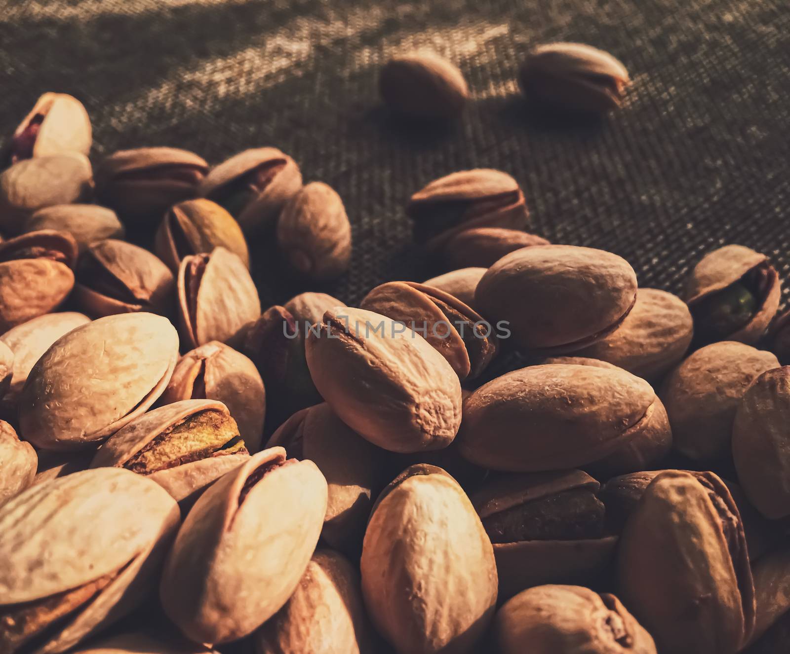 Pistachio nuts on rustic linen background, food and nutrition