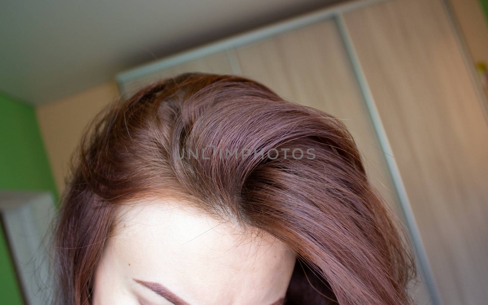 hair on a woman's head close-up. Hair brown color of