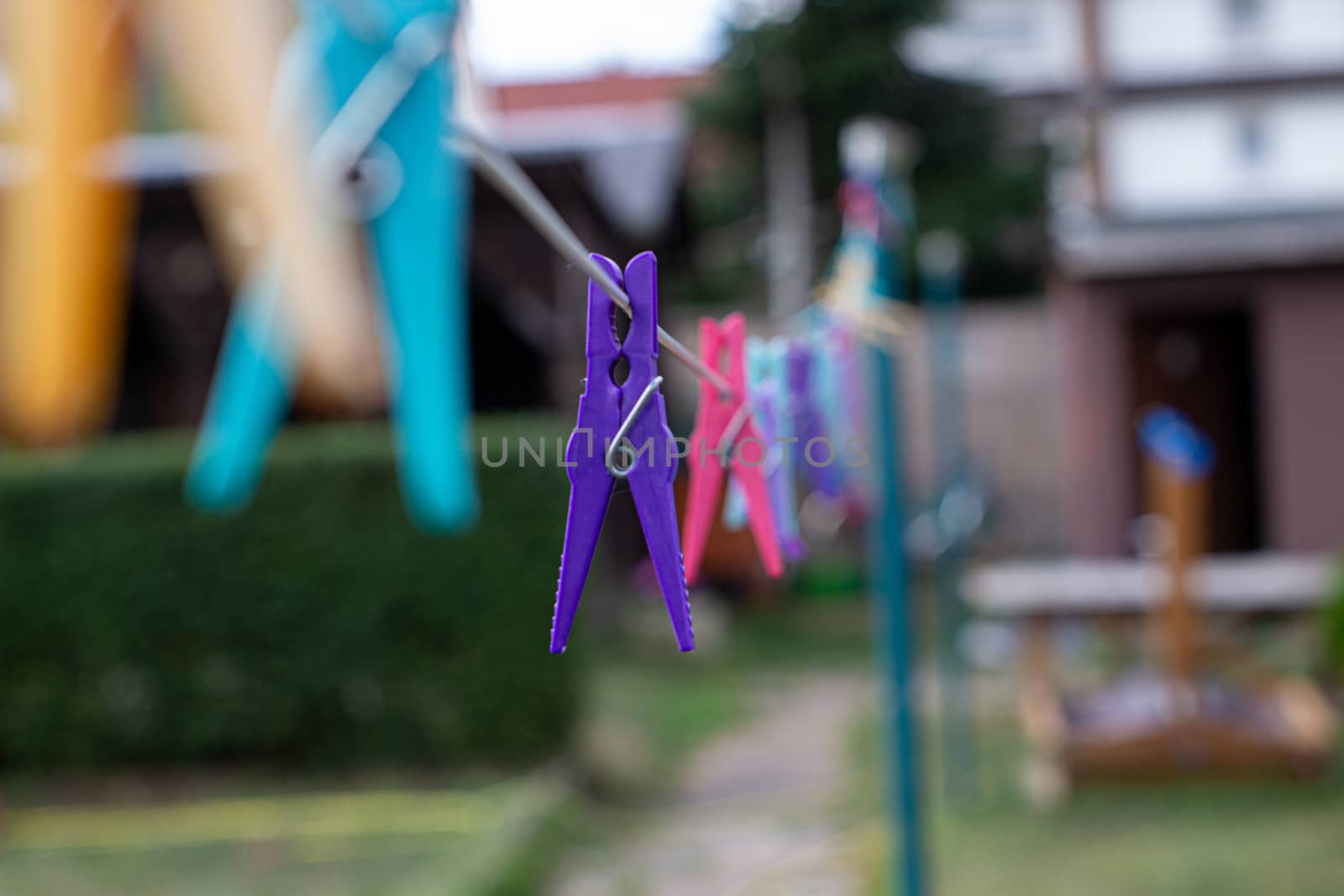 Colorful plastic clothespins on the hangers, clothespins on the hangers rope for wash clothes by AnatoliiFoto