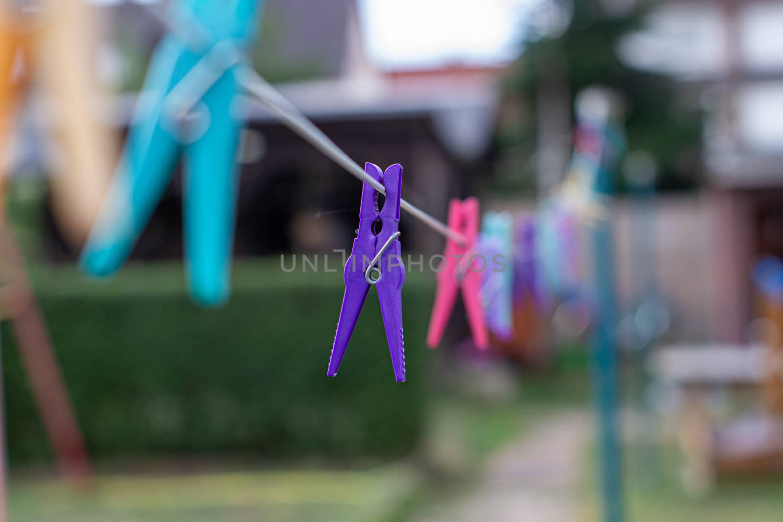 Colorful plastic clothespins on the hangers, clothespins on the hangers rope for wash clothes by AnatoliiFoto