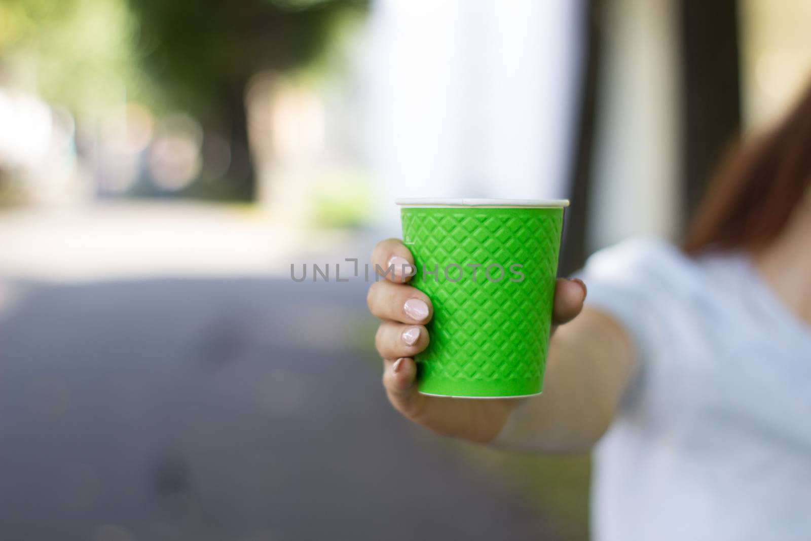 Mock up of cup coffee in woman's hand bright background for break, energy and strength, hot drink in paper cup. Tea or lemonade with ice, drink for business woman