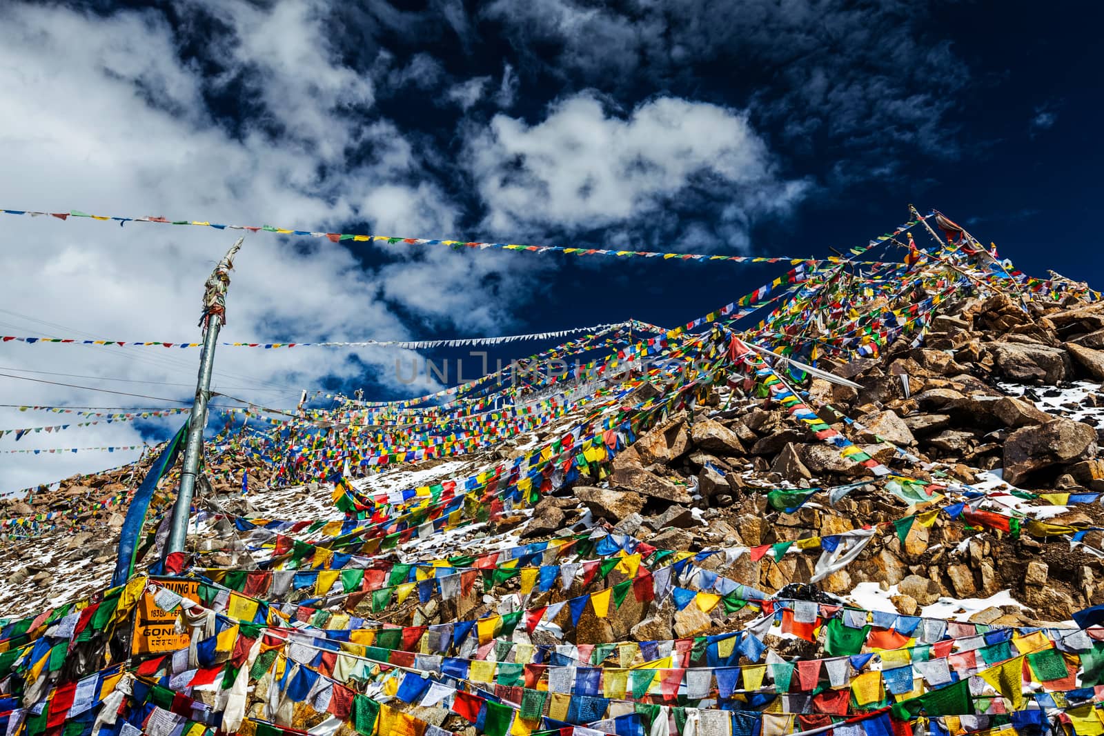 Tibetan prayer flags of Buddhism with Buddhist mantra on it on top of Himalayan pass Khardung La. It's the highest motorable pass in the world 5602m. On the way from Leh to Nubra valley. Ladakh, India
