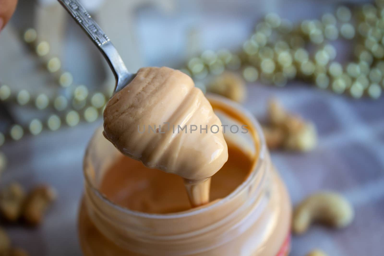 Creamy peanut butter and spoon on background.