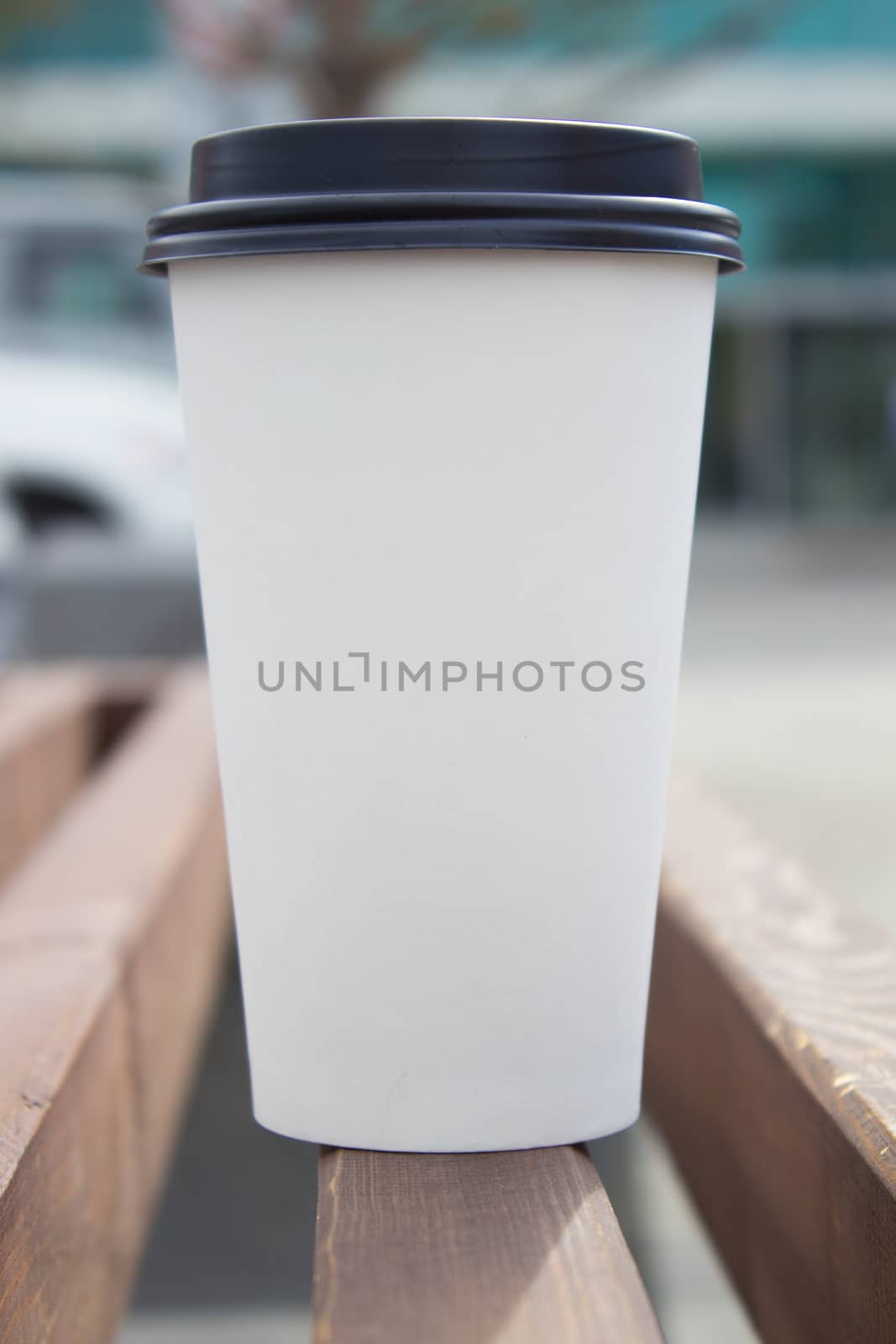 white paper coffee Cup with black plastic lid, outside. Coffee advertising by AnatoliiFoto