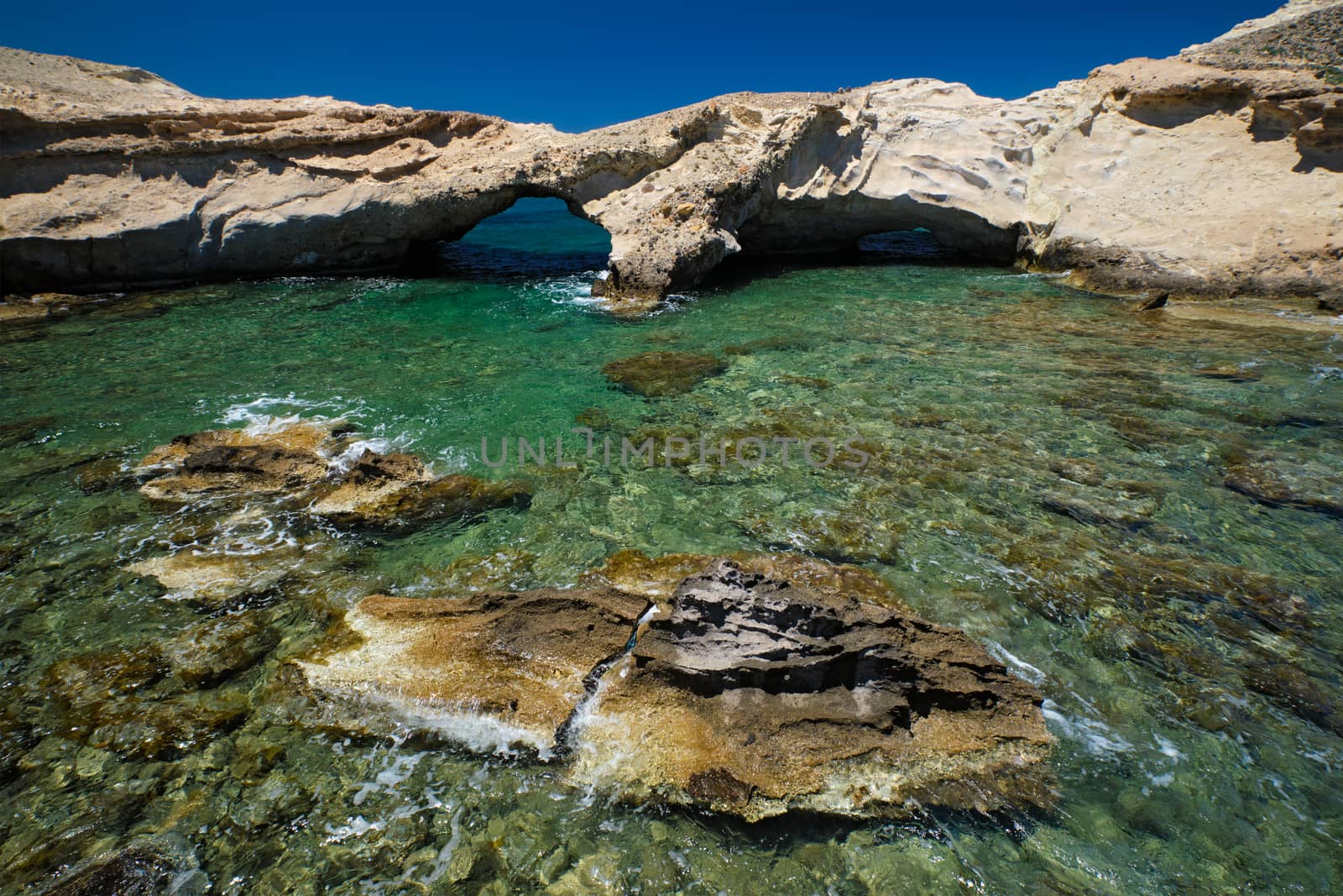 The beach of Agios Konstantinos with crystal clear turquoise water and rock formations in Milos island, Greece