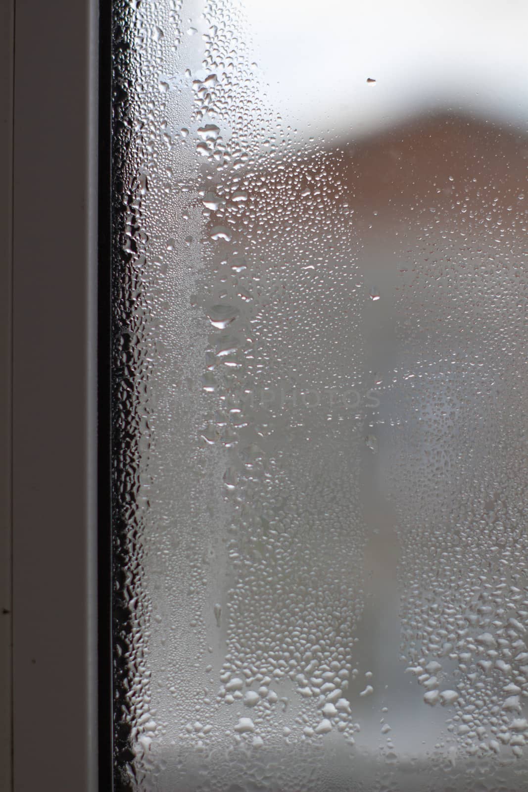 Close-up clear drops of water on window glass surface.